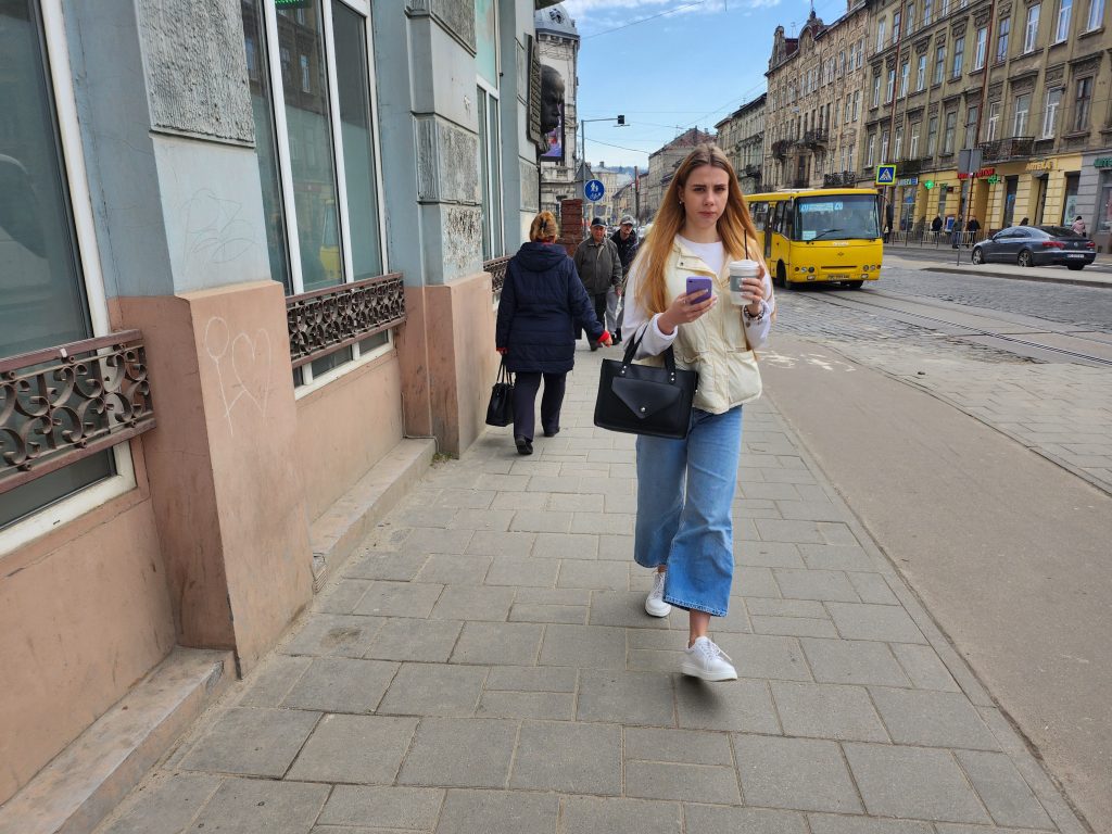 르비우 시내에서 쉽게 볼 수 있는 커피잔을 들고 걸으면서 동시에 핸드폰을 사용하는 여성들